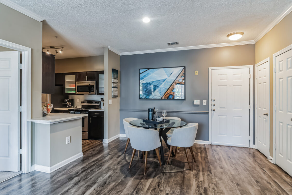 View of dining area and way to kitchen with dark wood and glass cabinets