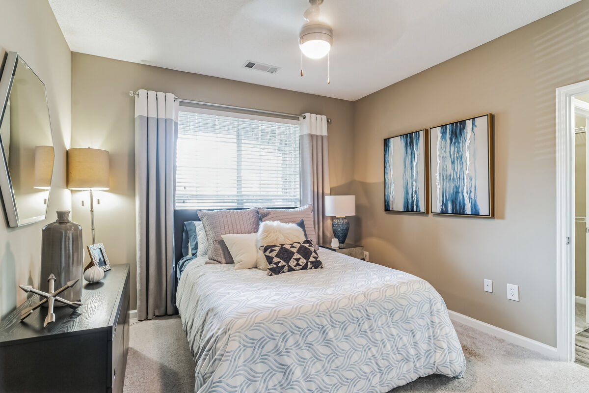 Bedroom with colorful pillows, dual art wall and walk through to bathroom
