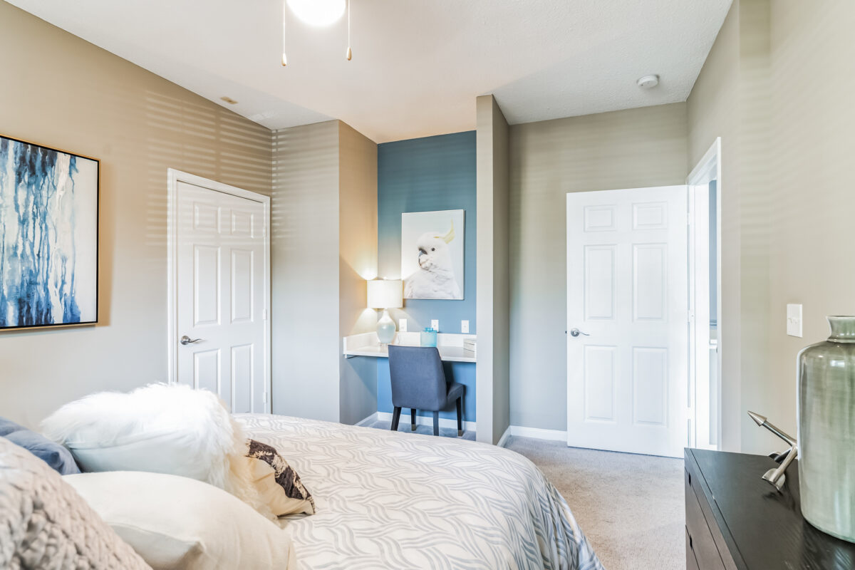 Bedroom with office space and open door leading to living space