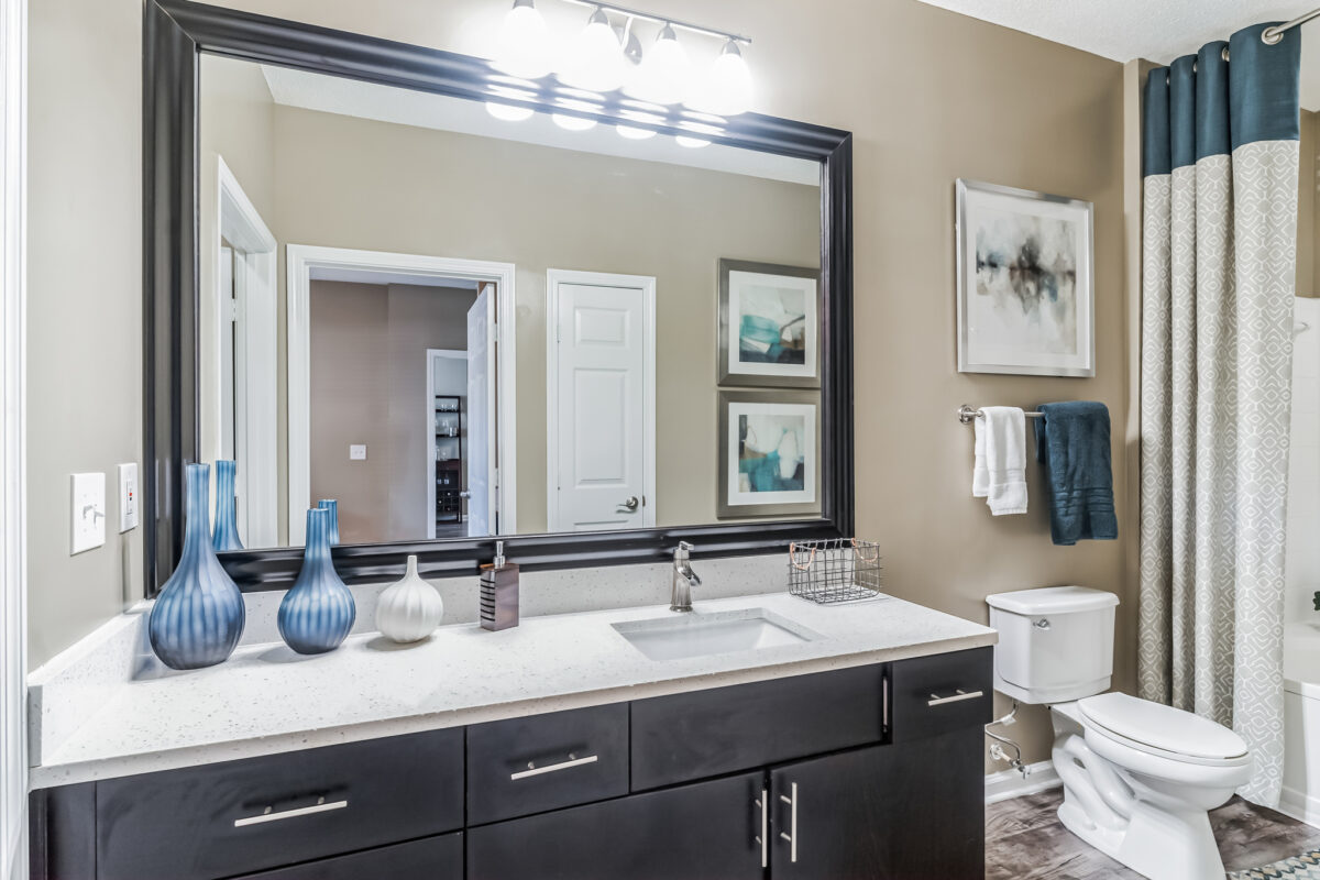 Bathroom with a dark framed large mirror, art wall, shower area