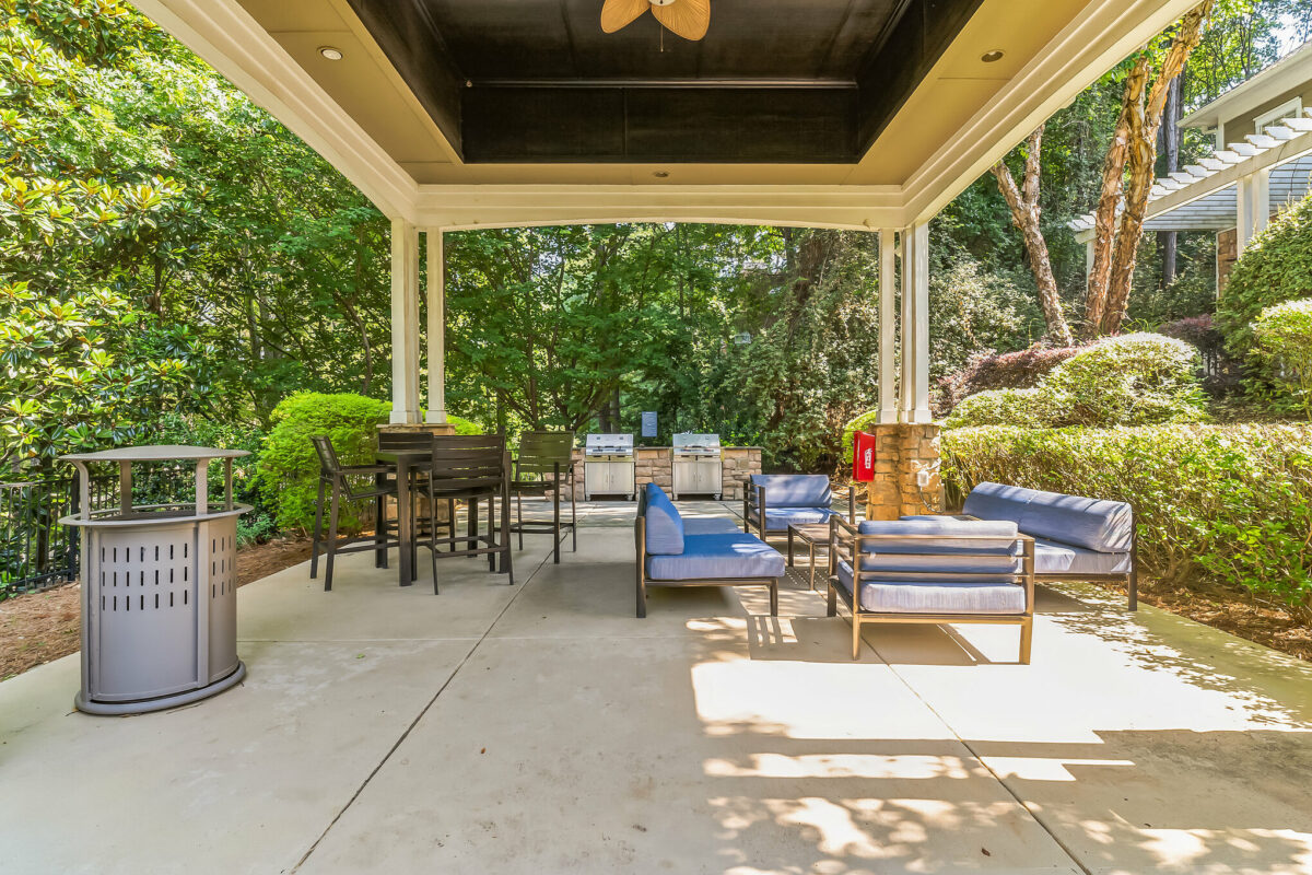 Outdoor clubhouse sitting area with table and chairs, couches