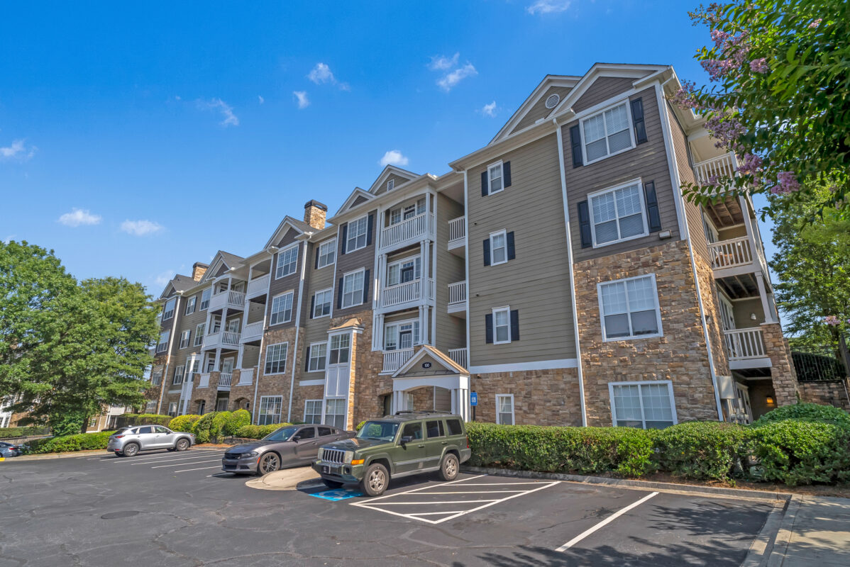 wide angle shot of apartments and parking lot with cars